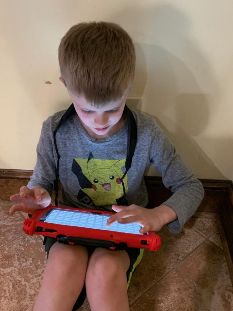 little boy using his speech device for communication