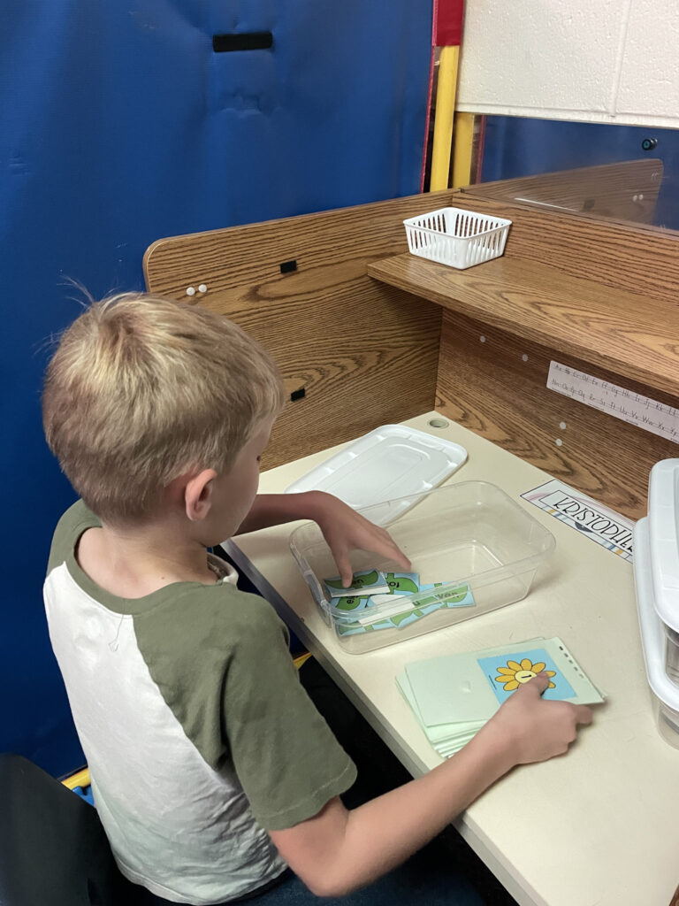 boy sitting at special needs classroom desk